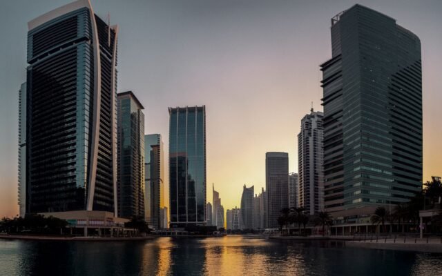 Stunning view of Dubai's modern skyline reflecting at sunset, showcasing iconic architecture.