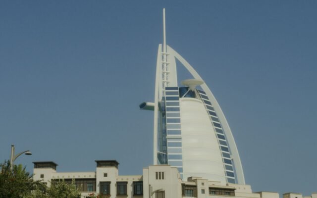 Iconic Burj Al Arab tower standing tall in Dubai under a clear blue sky.